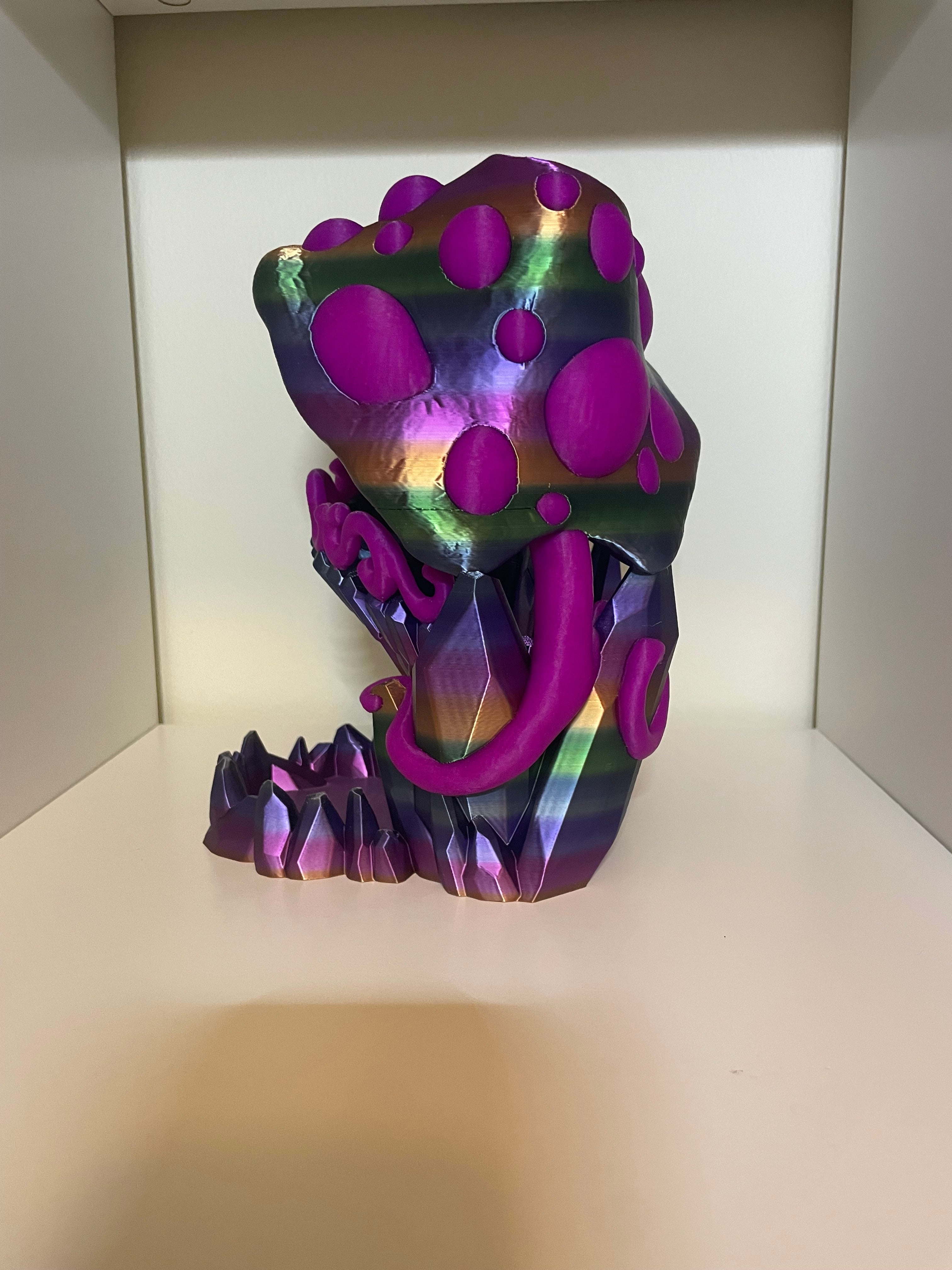 A colorful 3D-printed figurine of a mushroom with a glossy, iridescent surface and bright magenta-purple caps and stem. side view of two tone