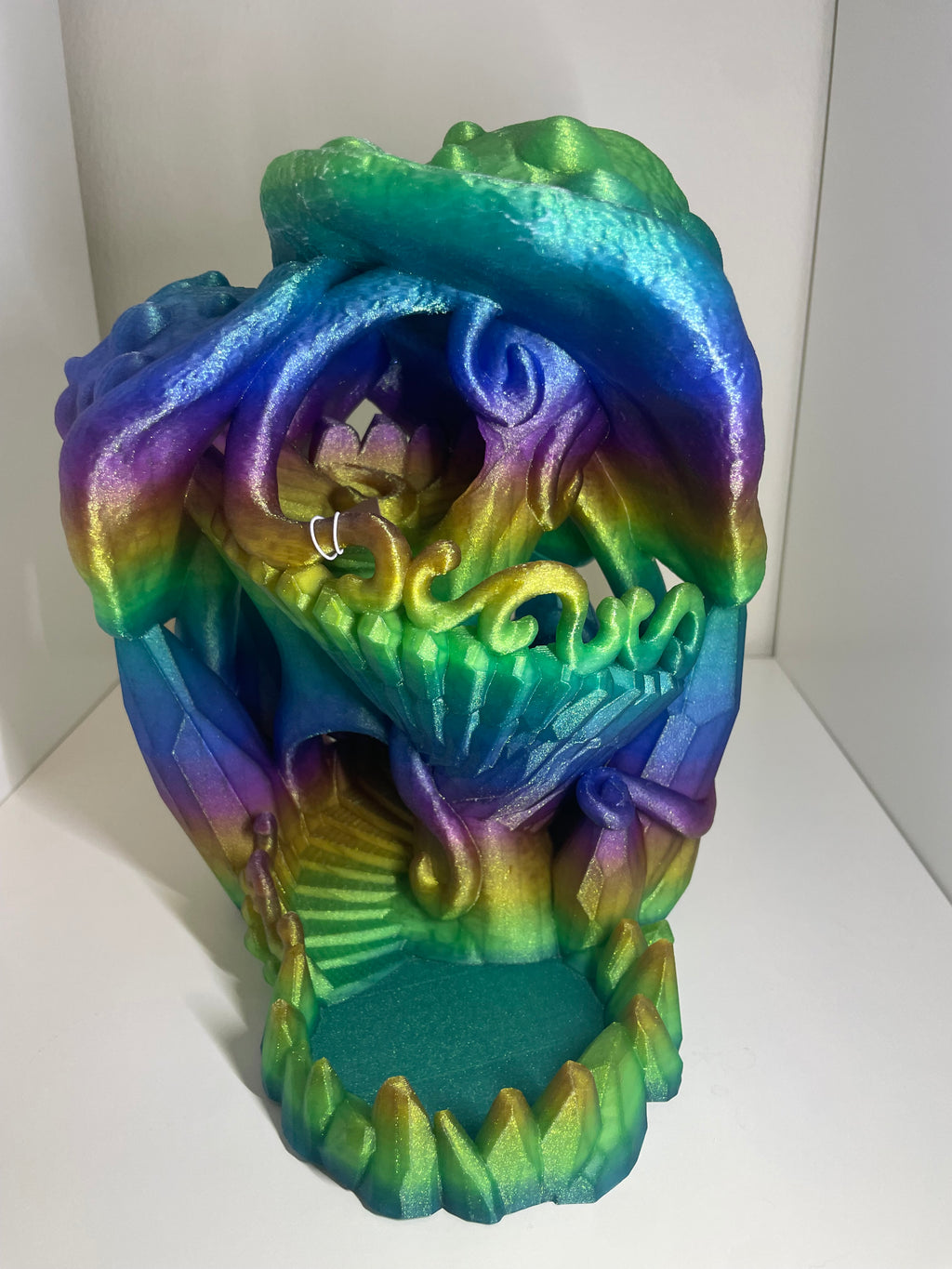 A 3D-printed decorative object with a multicolor iridescent gradient of blue, green, yellow, and purple. one color